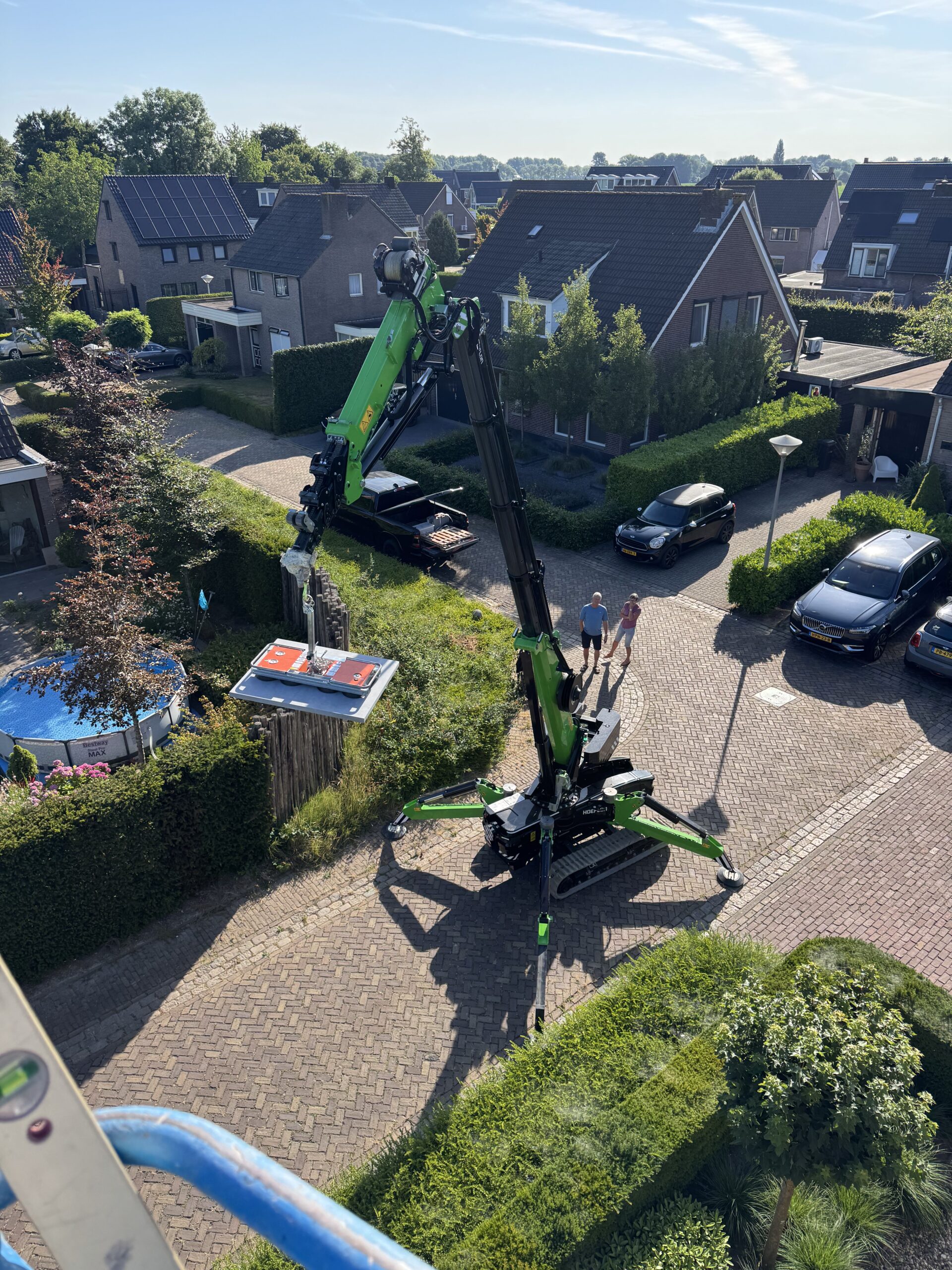 Boven aanzicht van het hijsen van een zware stenen tegel met glaszuiger