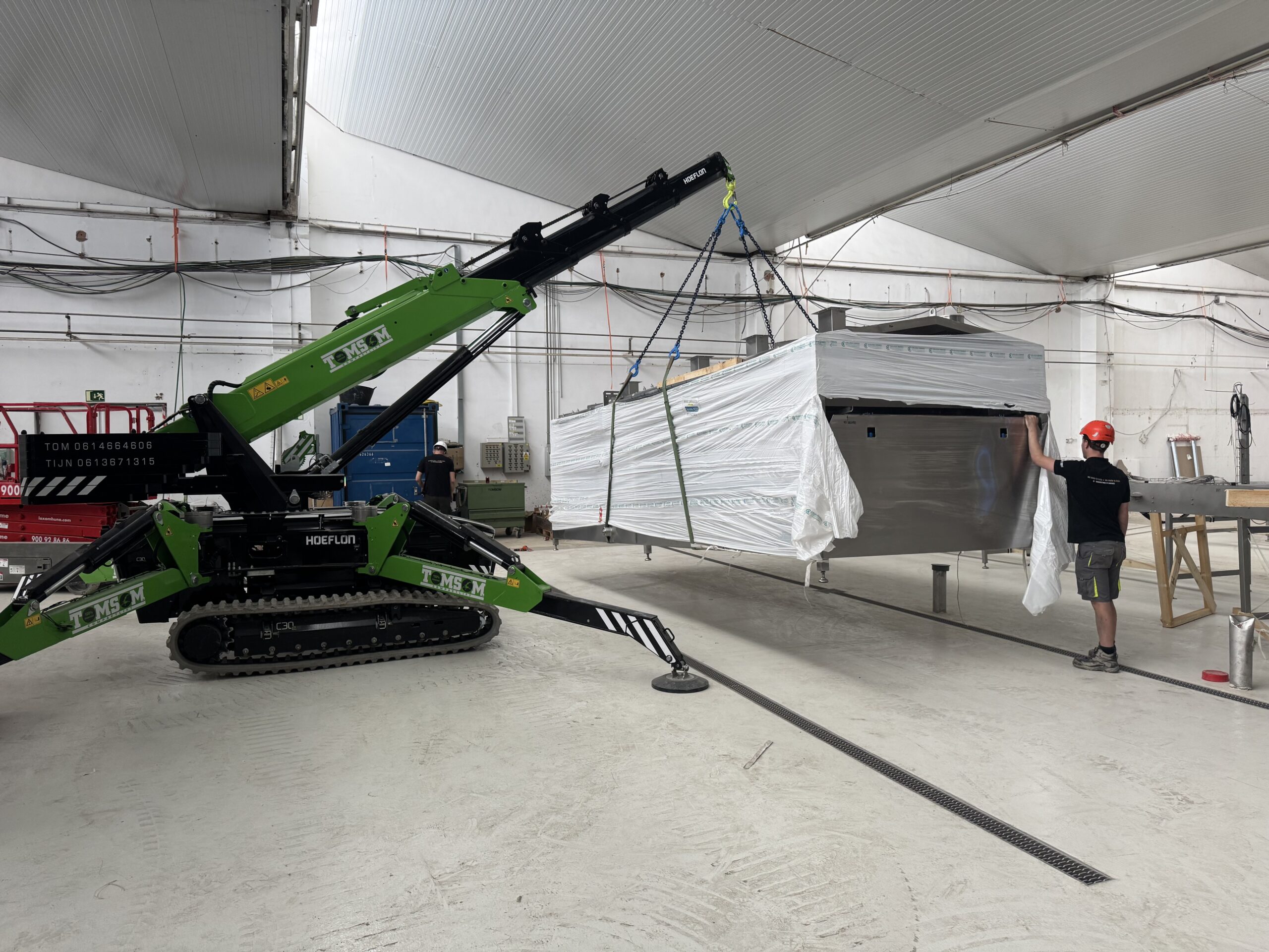 Grote machine plaatsen met Hoeflon minihijskraan in het buitenland