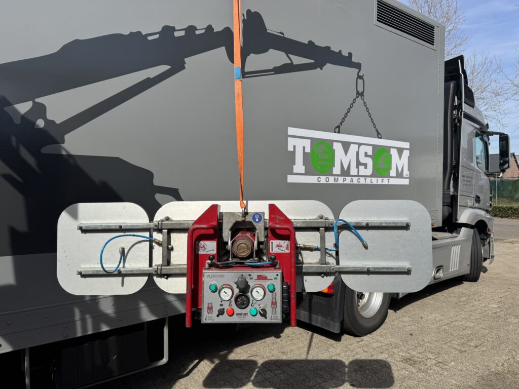 Hoeflon VL500 glaszuiger met vrachtwager TOMSOM Compactlift op de achtergrond