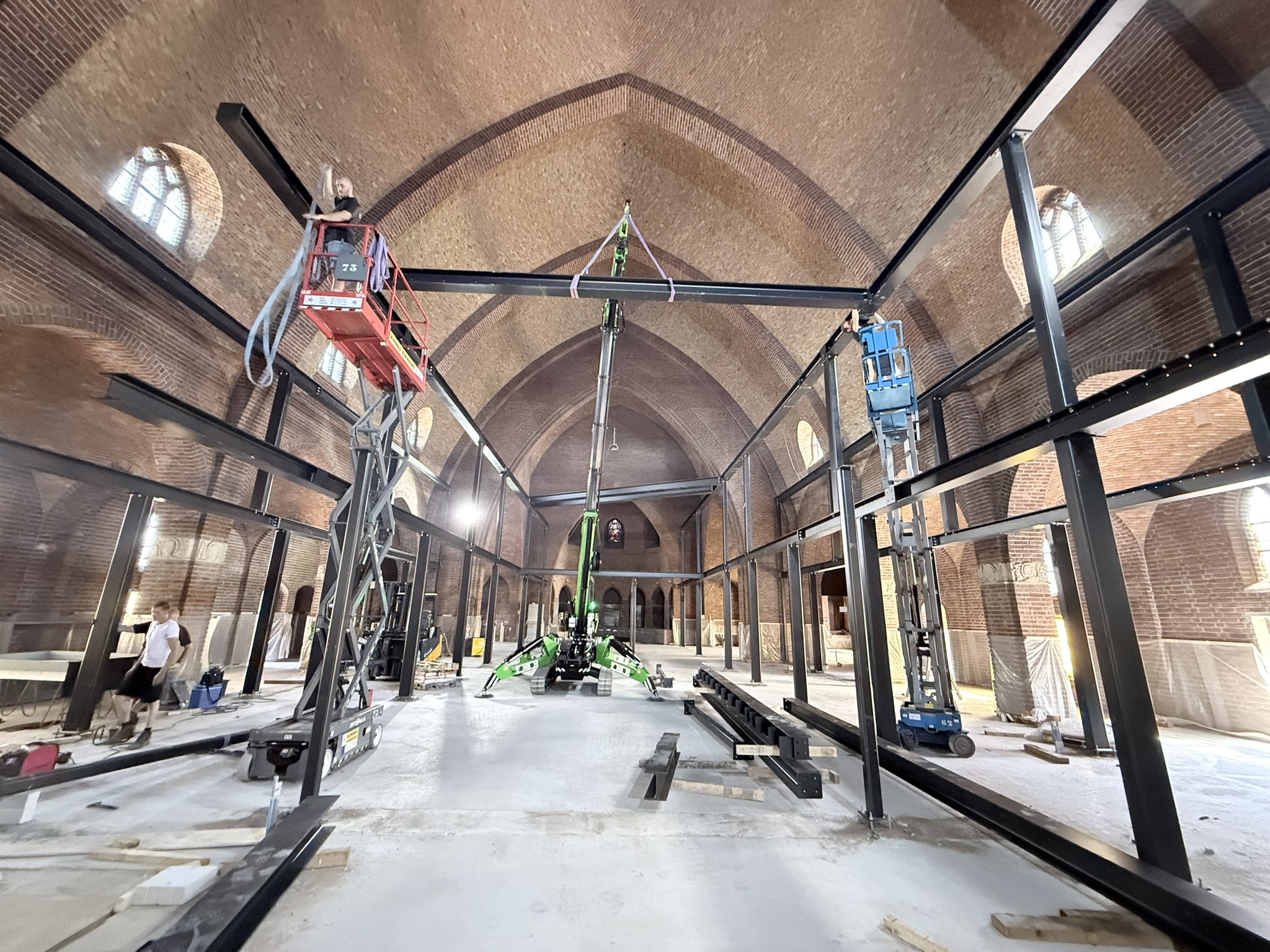 Stalen constructie zetten in een kerk met elektrische hijskraan