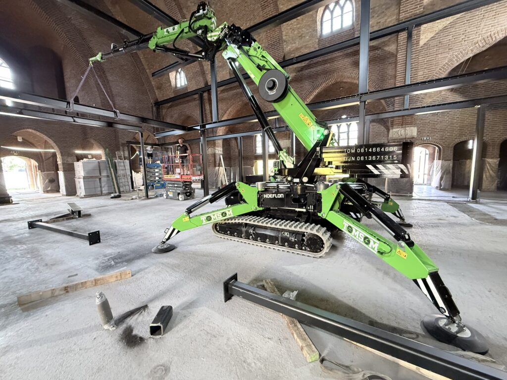 Stalen constructie zetten in een kerk met elektrische hijskraan