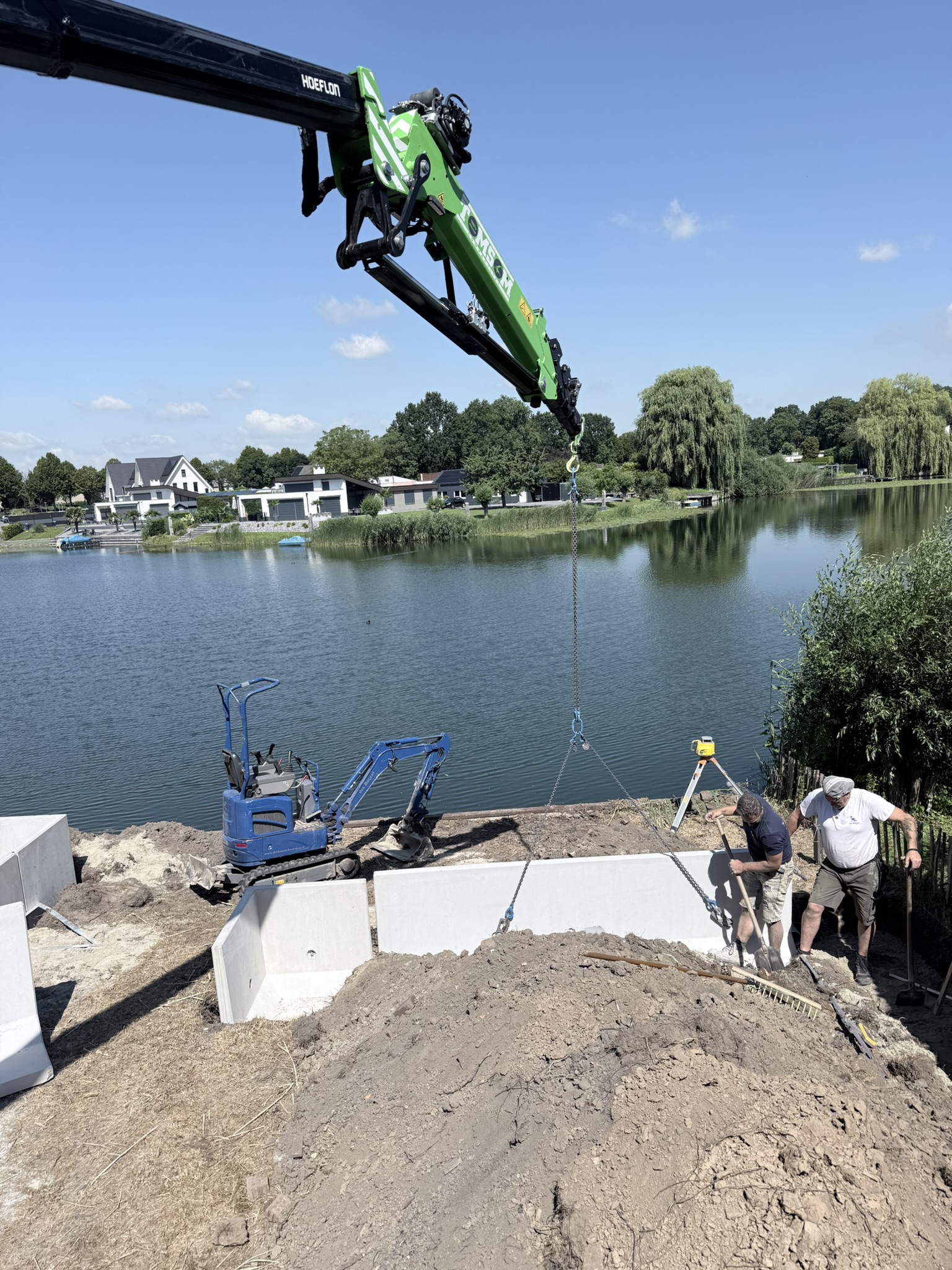 Betonnen prefab kelder zetten met Hoeflon kraan aan de waterkant