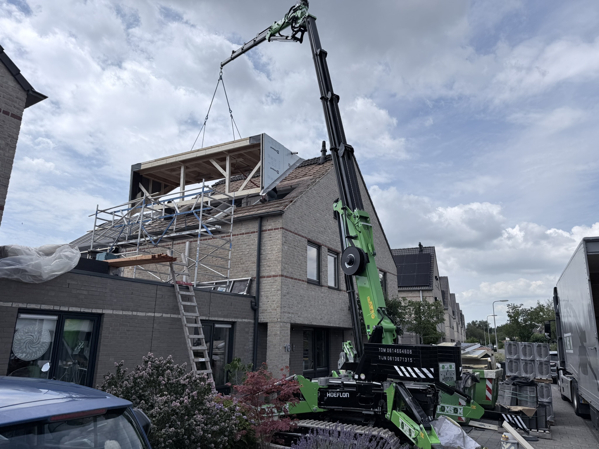 Volledig dakkapel hijsen in een woonwijk met Hoeflon C30e kraan